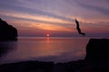 Asian girls jump from a cliff into the sea episode sunset.