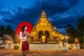 Asian girls in traditional costumes visit Wat Xiengthong Popular temples in Luang Prabang, Laos at night Royalty Free Stock Photo