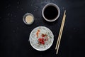 Asian glass fungoza rice noodles and bamboo sticks on a wooden board in a white round bowl with sesame seeds on a black slate