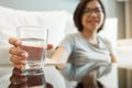 Asian glasses woman holding glass of water