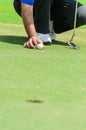 Asian golf player squatting to put down Royalty Free Stock Photo