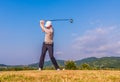 Asian golfer hitting golf ball on green fairway Royalty Free Stock Photo