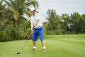Asian Man Swinging Club For Tee-off In Course