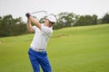 Asian man swinging club for tee-off in course Royalty Free Stock Photo