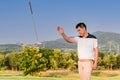 Asian golfer young man standing and angry gesture by thrown away putter on green in golf course after putting golf ball not hole Royalty Free Stock Photo