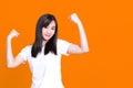 Asian gorgeous strong young pin-up woman smiling  over background wall showing biceps screaming Royalty Free Stock Photo