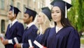 Asian graduate student with diploma, smiling into camera, international studies Royalty Free Stock Photo