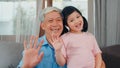 Asian grandfather and granddaughter video call at home. Senior Chinese grandpa happy with young girl using mobile phone video call Royalty Free Stock Photo