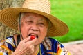 An Asian grandmother is eating a small tomato Royalty Free Stock Photo