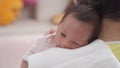 Asian grandmother holding baby infant on shoulder and lulling to sleep. mother tapping baby back to belch after feeding breast mil