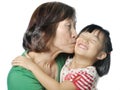 Asian grandmother kissing her granddaughter's cheek