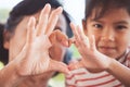 Asian grandmother and little child girl making heart shape with hands together Royalty Free Stock Photo