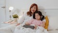 Asian grandmother using tablet read fairy tales to granddaughter at home. Senior Chinese, grandma happy relax with young girl Royalty Free Stock Photo