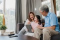 Asian grandparents and granddaughter using tablet at home. Senior Chinese, grandpa and grandma happy spend family time relax with Royalty Free Stock Photo