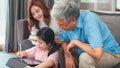 Asian grandparents and granddaughter video call at home. Senior Chinese, grandpa and grandma happy with girl using mobile phone Royalty Free Stock Photo