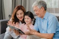 Asian grandparents and granddaughter video call at home. Senior Chinese, grandpa and grandma happy with girl using mobile phone Royalty Free Stock Photo