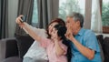 Asian grandparents selfie with granddaughter at home. Senior Chinese, grandpa and grandma happy spend family time relax using