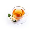 Asian green tea with jasmine flower in transparent teacup isolated on white background with reflection