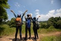 Asian Group of young people with friends backpacks walking together and happy friends are raised arms and enjoying a beautiful Royalty Free Stock Photo