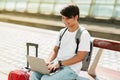 Asian guy freelancer working on laptop while waiting for train Royalty Free Stock Photo