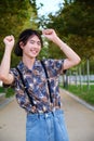 Asian guy smiling and dancing rock and roll in a park. Royalty Free Stock Photo