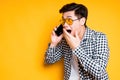 Asian guy in sunglasses talking on the phone surprised and covering his mouth with his hand Royalty Free Stock Photo