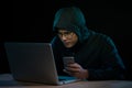 Asian hacker hacking computer network with laptop in dark. Cyber security concept Royalty Free Stock Photo