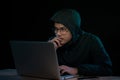 Asian hacker hacking computer network with laptop in dark. Cyber security concept Royalty Free Stock Photo