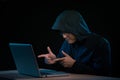 Asian hacker hacking computer network with laptop in dark. Cyber security concept Royalty Free Stock Photo