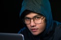 Asian hacker hacking computer network with laptop in dark. Cyber security concept Royalty Free Stock Photo