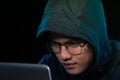 Asian hacker hacking computer network with laptop in dark. Cyber security concept Royalty Free Stock Photo