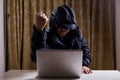 Asian hacker show fist while hacking computer network