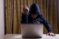 Asian hacker show fist while hacking computer network