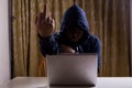 Asian hacker show middle finger while hacking computer network