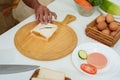 Asian hand close up Garnishing the egg sandwich After using a knife to cut a sandwich that was placed on a wooden chopping board. Royalty Free Stock Photo