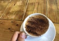 Asian hand holding cup of coffee