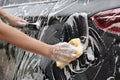 Asian hand holds sponge with car wash To clear the sides of the