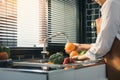 Asian hands woman washing fruit orange and preparation healthy food in kitchen