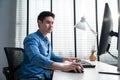 Asian handsome business man using laptop computer working in office. Attractive professional male employee worker sitting on table