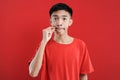 Asian handsome man doing silence gesture isolated on red background Royalty Free Stock Photo