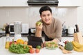 Asian handsome man looking recipe on laptop in kitchen at home Royalty Free Stock Photo