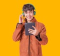Asian handsome man smiling and listening music by big green headphones by smartphone search Royalty Free Stock Photo