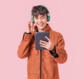 Asian handsome man smiling and listening music by big green headphones by smartphone search Royalty Free Stock Photo