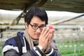 Asian handsome tourist man wearing overcoat in strawberry greenhouse