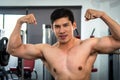 Asian handsome young muscular asian man exercising bodybuilder in front of a glass in the gym .Guy flexing trains his bicep Royalty Free Stock Photo