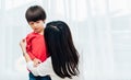 Asian happy beautiful mother getting dressed clothes on her kids Royalty Free Stock Photo