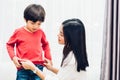 Asian happy beautiful mother getting dressed clothes on her kids Royalty Free Stock Photo