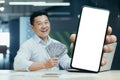 Asian happy businessman in office, showing phone screen with white Royalty Free Stock Photo