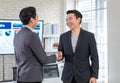 Asian happy cheerful handsome millennial professional successful male businessman in casual blazer standing smiling handshaking Royalty Free Stock Photo