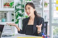 Asian happy cheerful professional successful female businesswoman employee in formal suit sitting smiling holding hands up Royalty Free Stock Photo